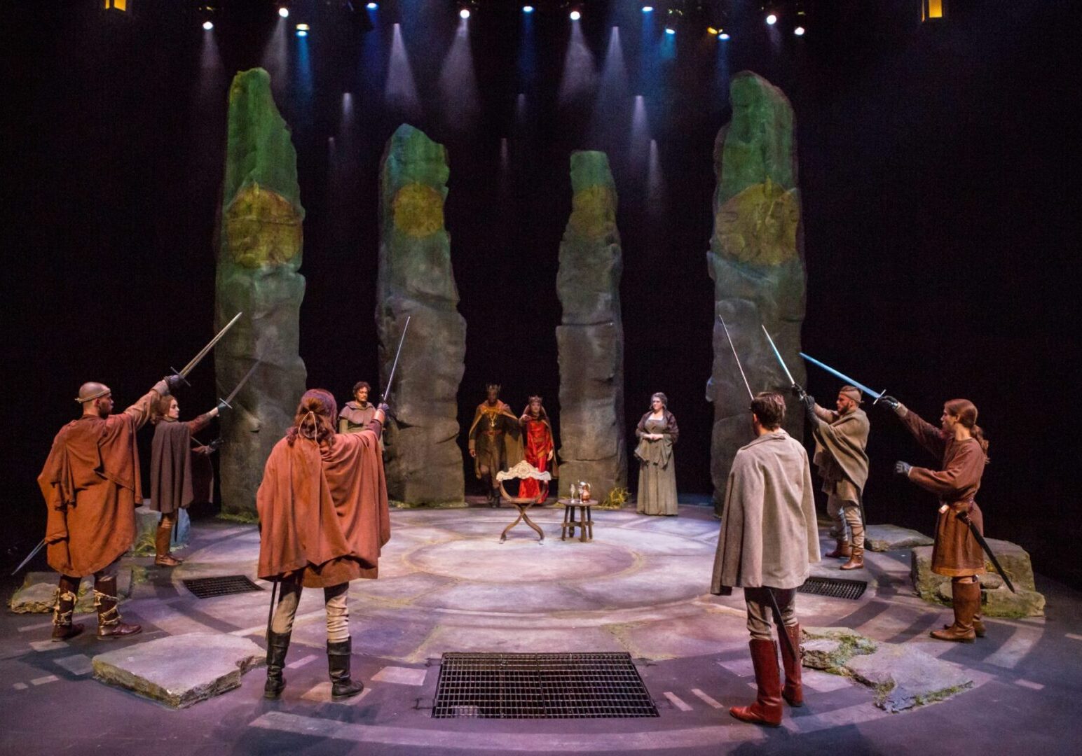Stage scene with actors and stone pillars