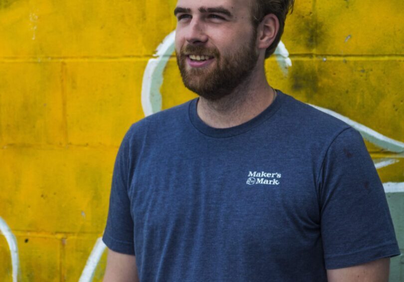 Man in blue shirt smiling outdoors