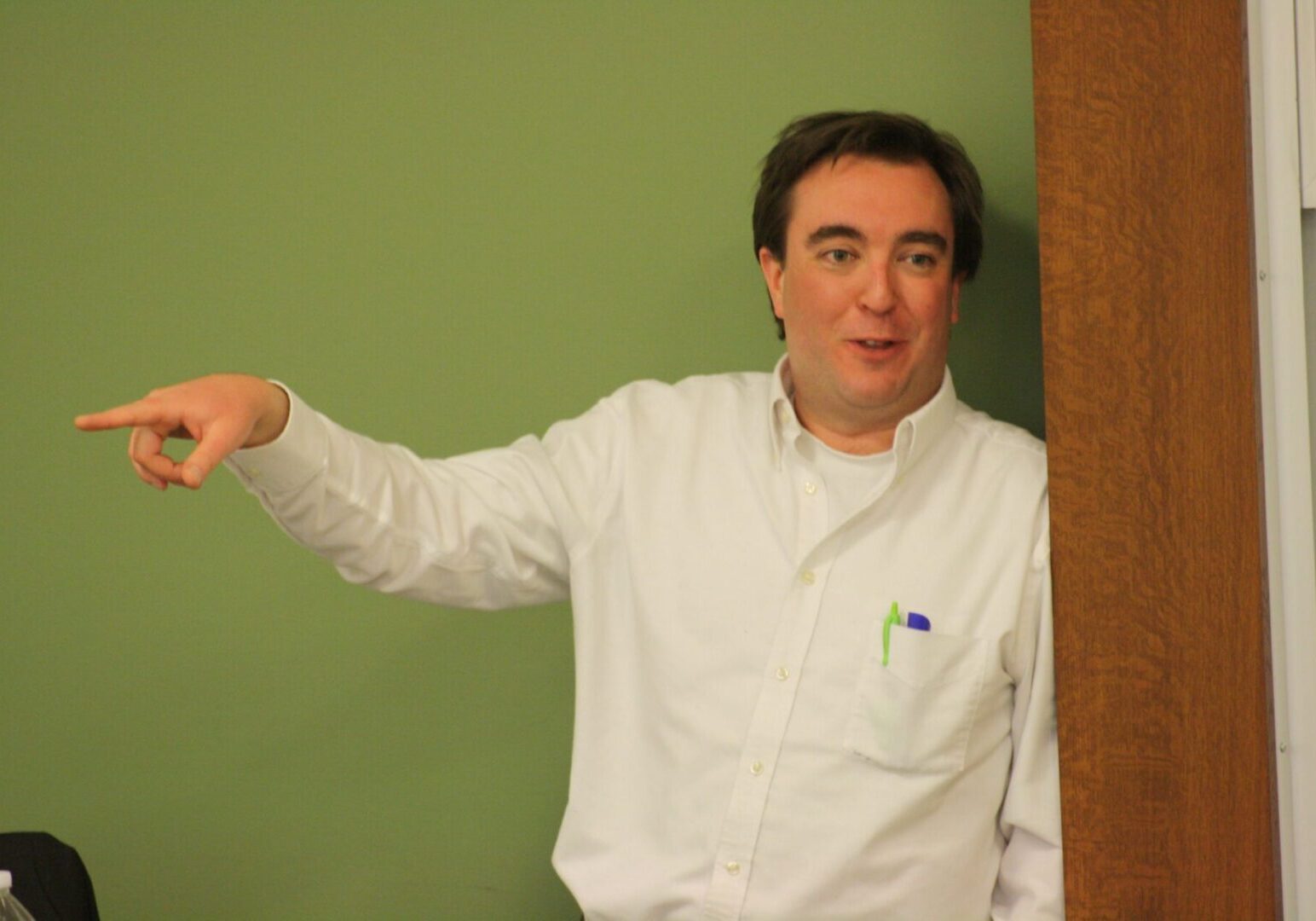 Individual in white shirt pointing left