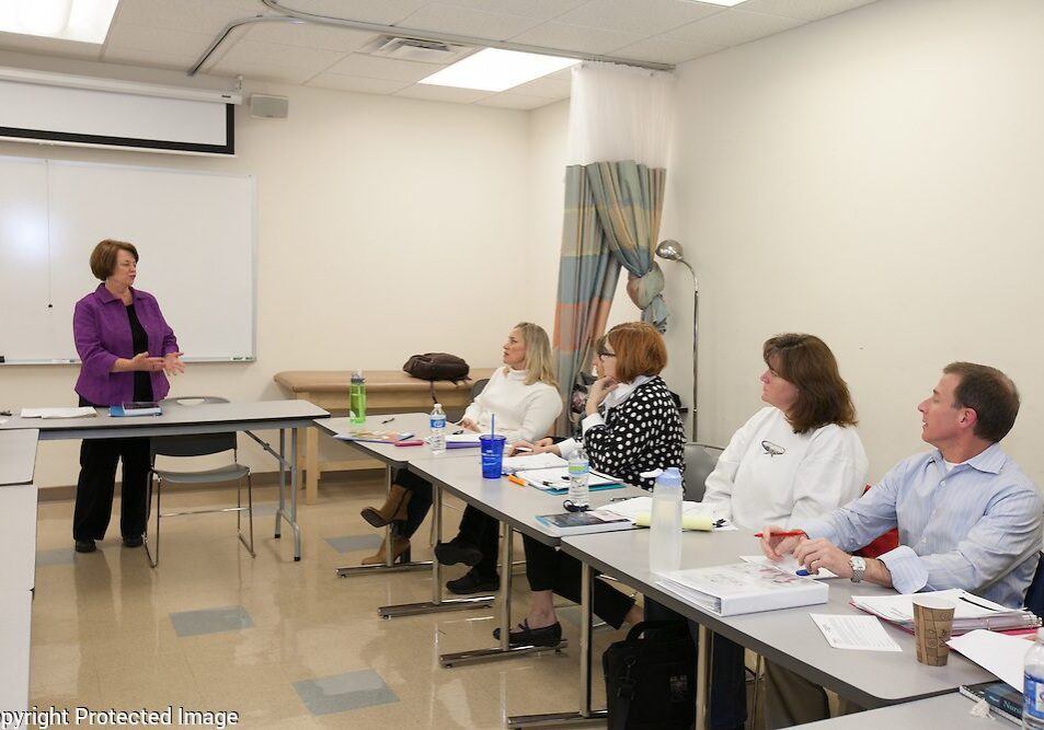 Woman presenting to attentive audience in classroom