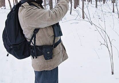 Photographer in snowy forest with camera