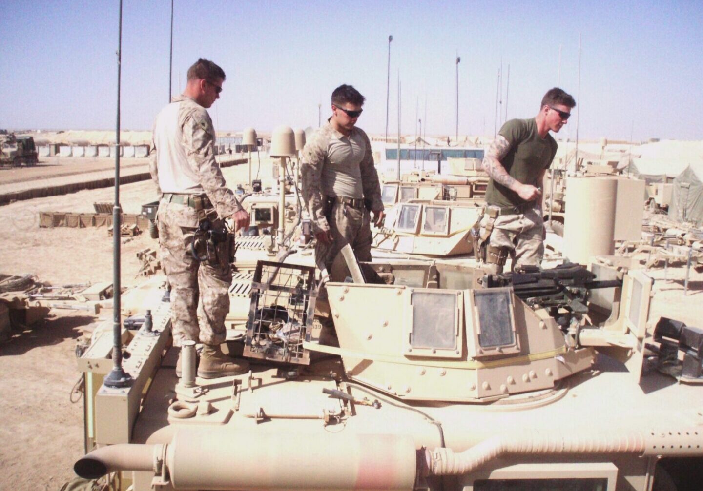 Military personnel on armored vehicle rooftop