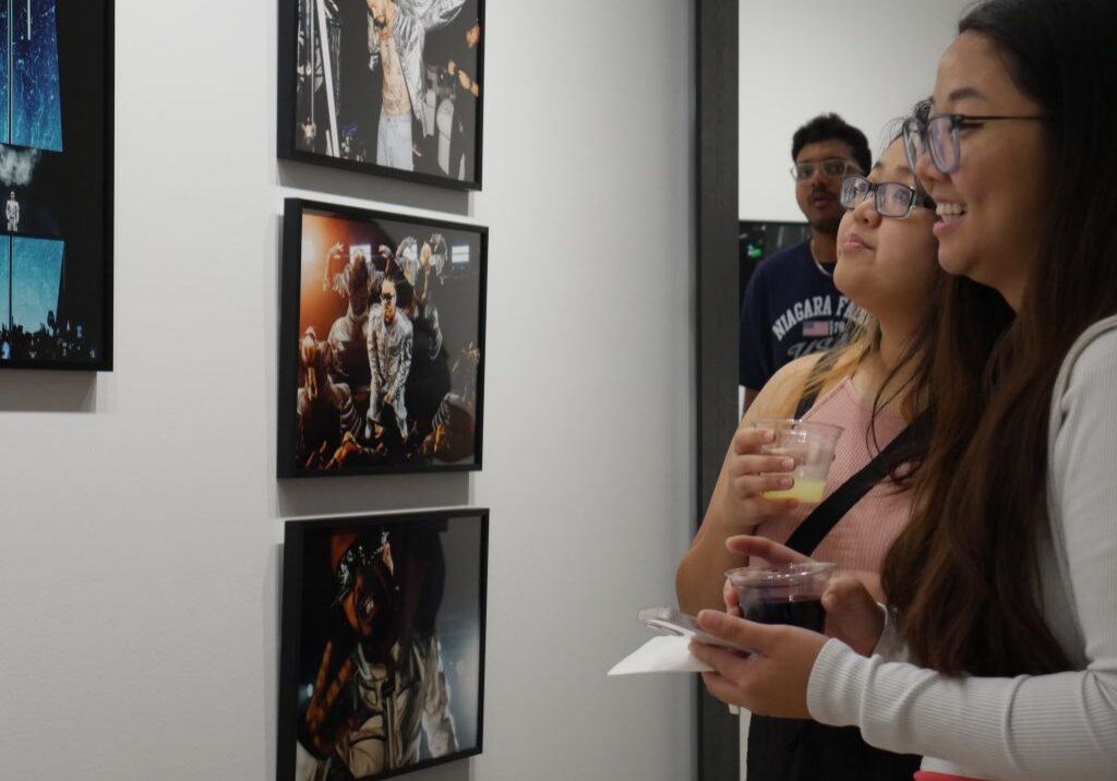 Two women admiring framed photographs