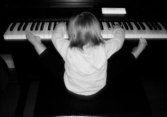 Toddler stretching while playing keyboard
