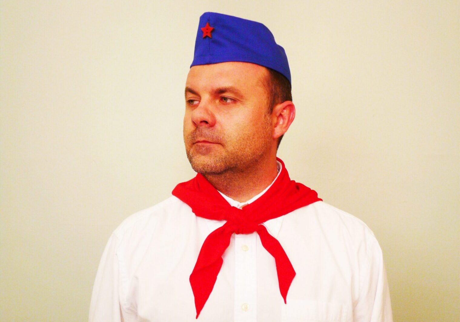 Person wearing a blue cap and red neckerchief