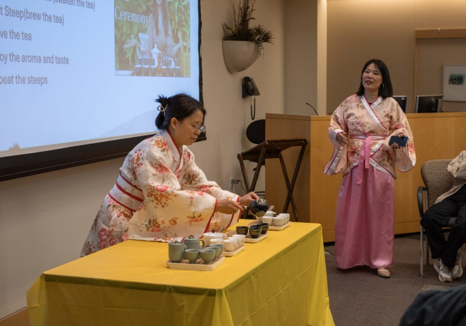 Tea ceremony presentation with two women in kimonos