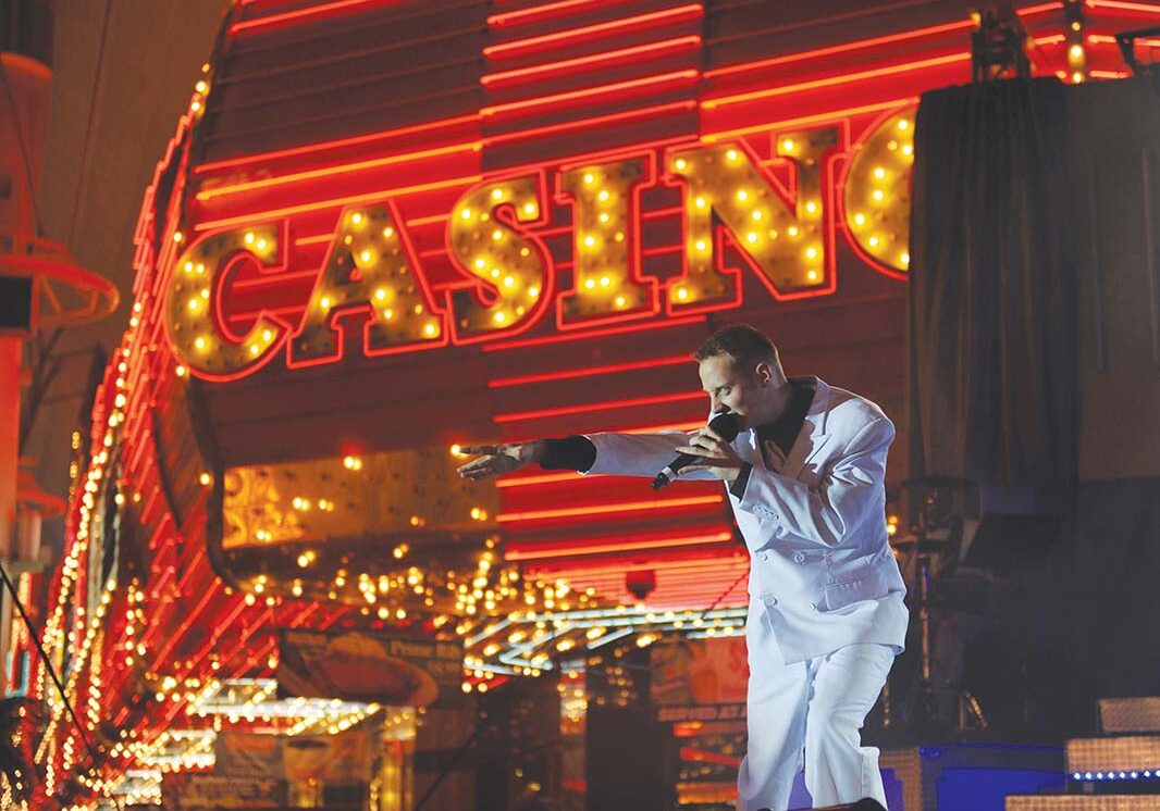 Nighttime performance near glowing casino lights