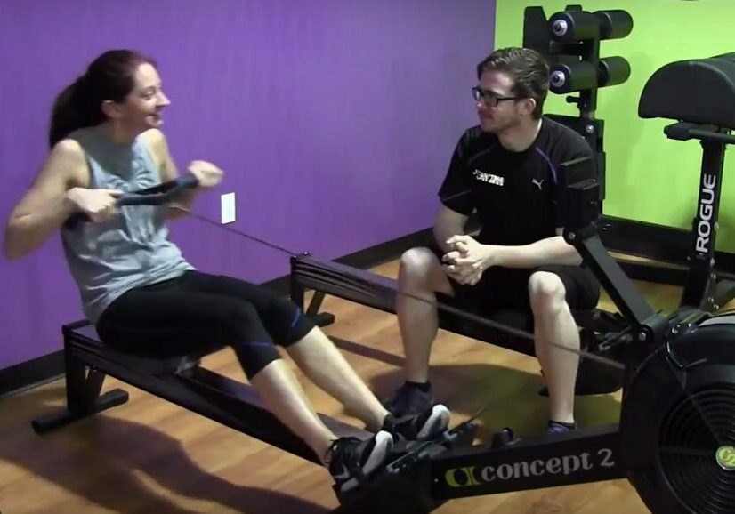 Personal trainer supervising rowing workout