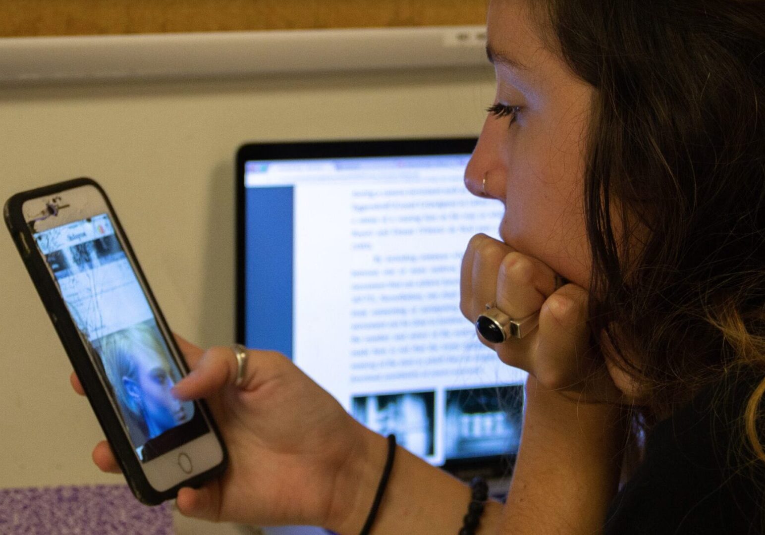 Woman multitasking with phone and laptop