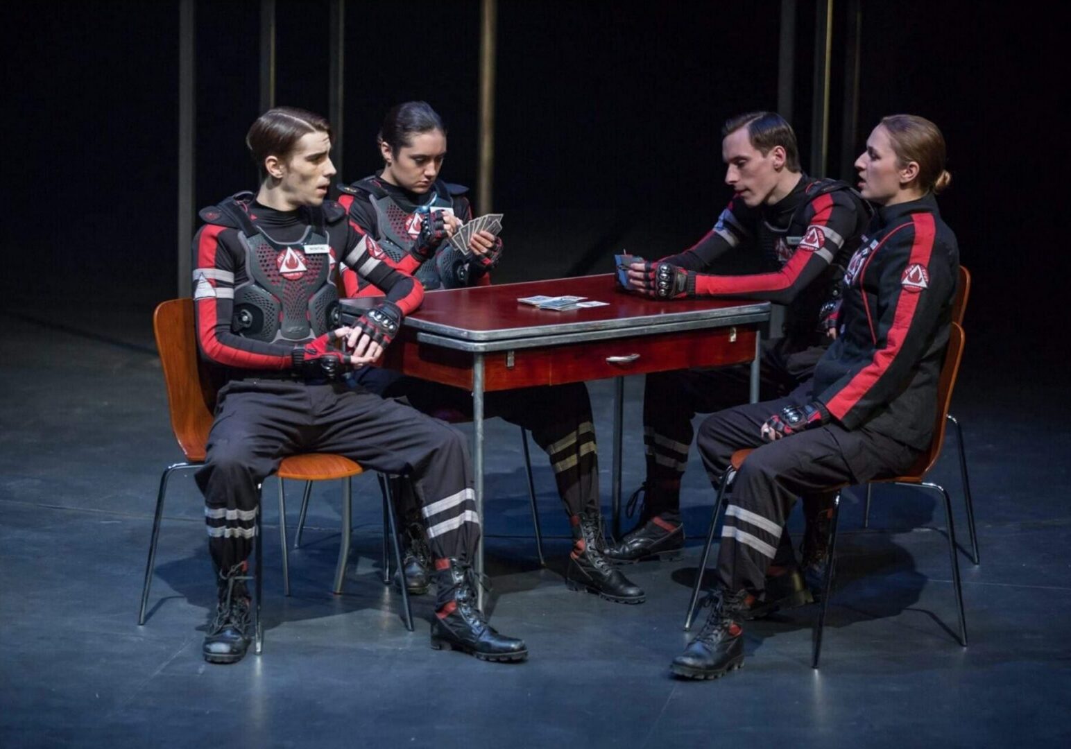 Group playing cards in a theatrical setting.