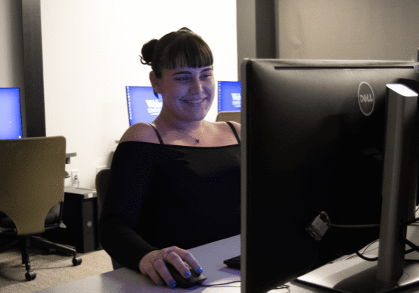 Woman smiling at computer screen