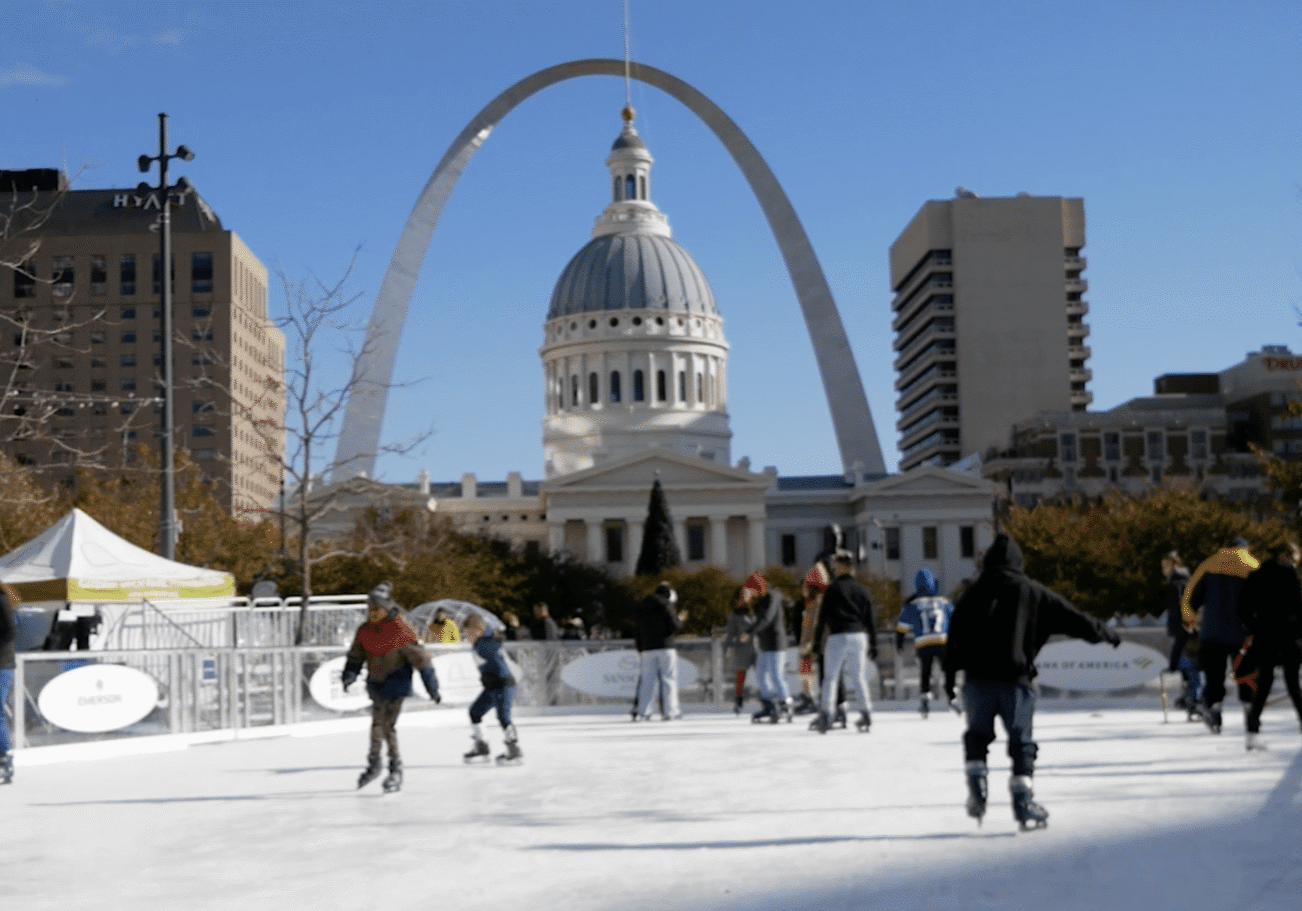 Ice rink bustling with skaters under clear sky