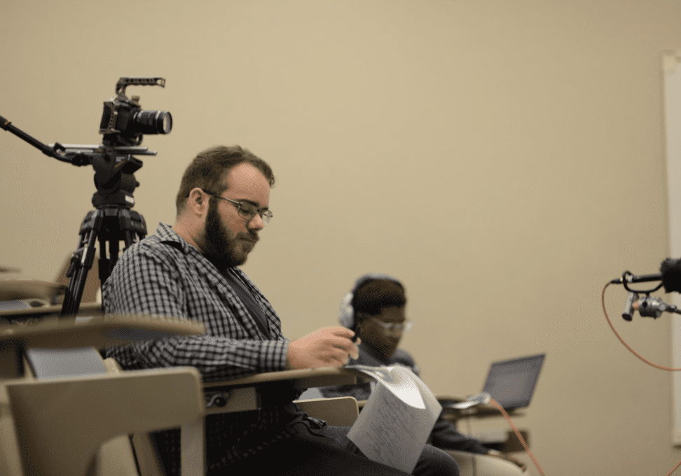 Man holding paper in lecture hall