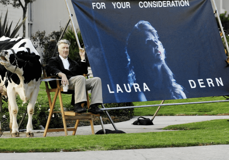Director sitting by film advertisement