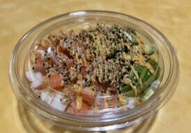 Salmon poke bowl with sauce drizzle