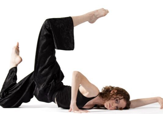 Dancer in black outfit on white background