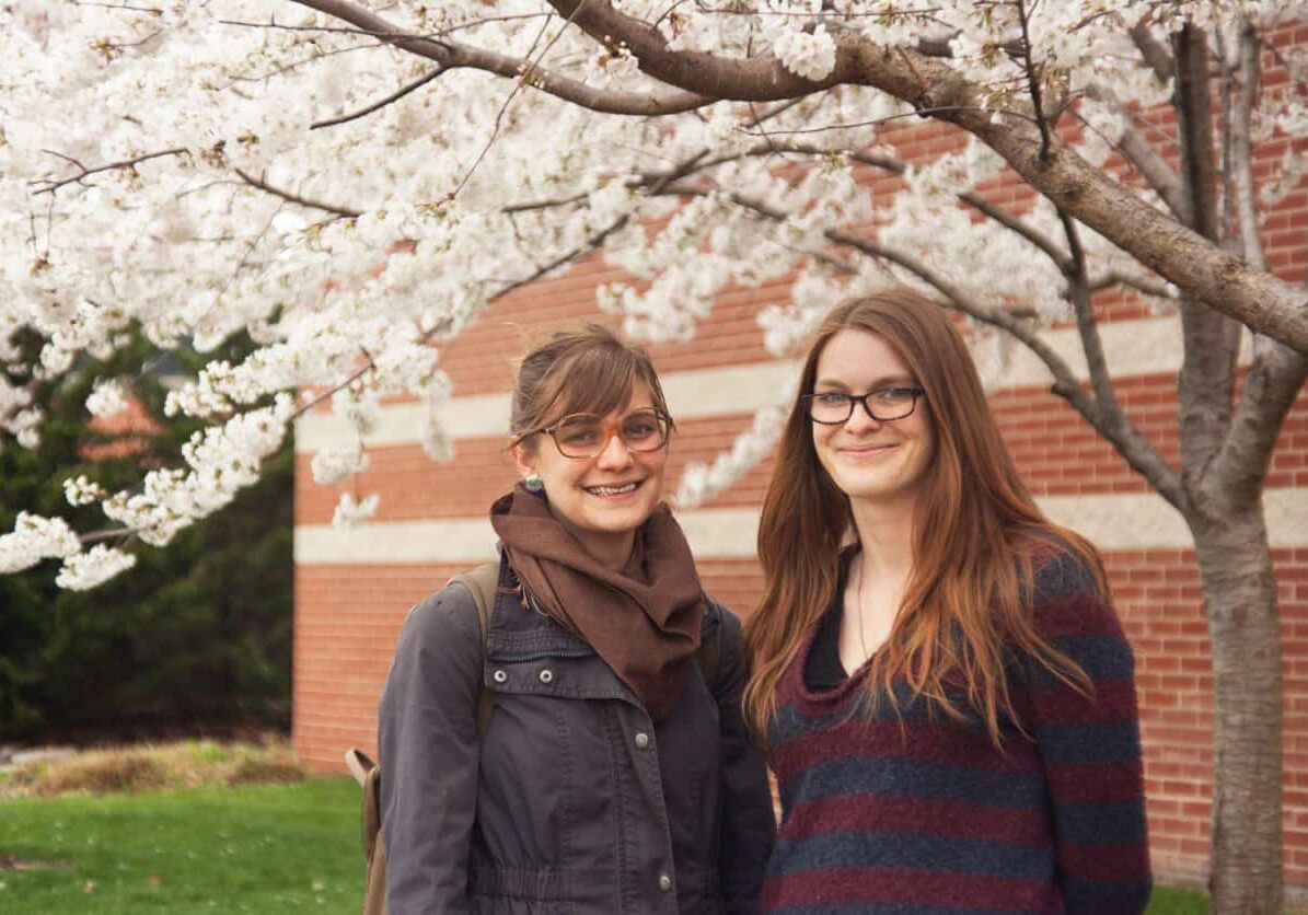 Friends enjoying springtime blossoms outdoors.