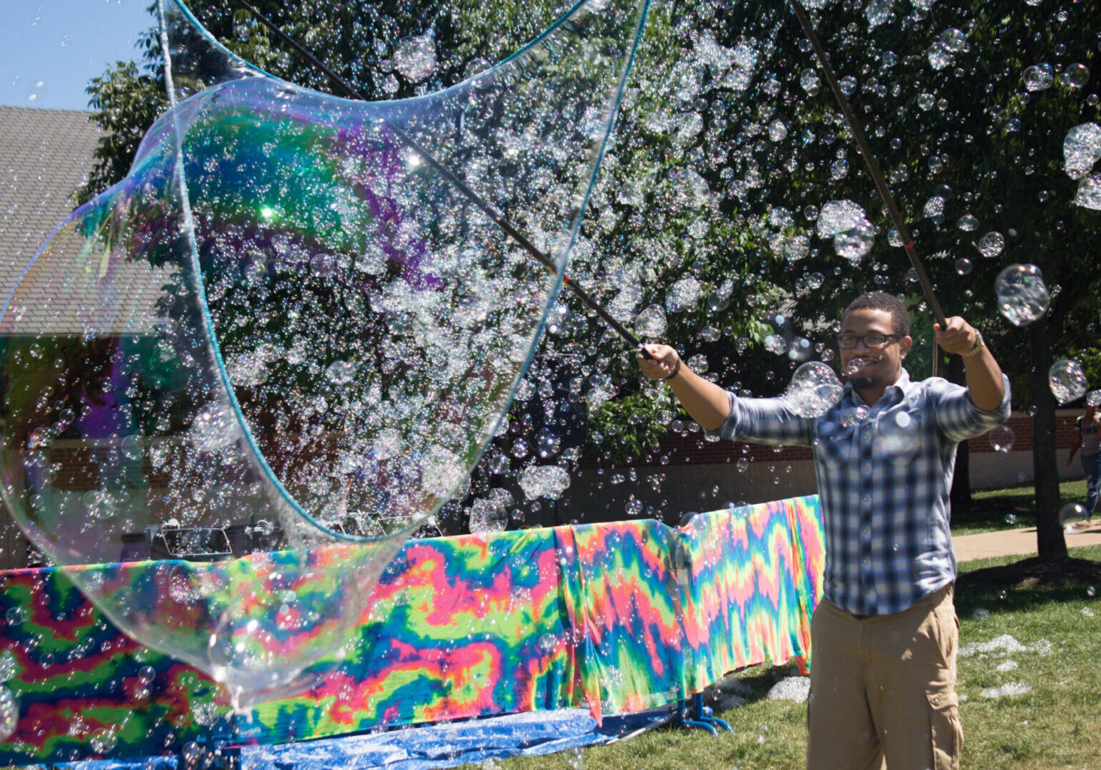 Person making colorful bubbles in park