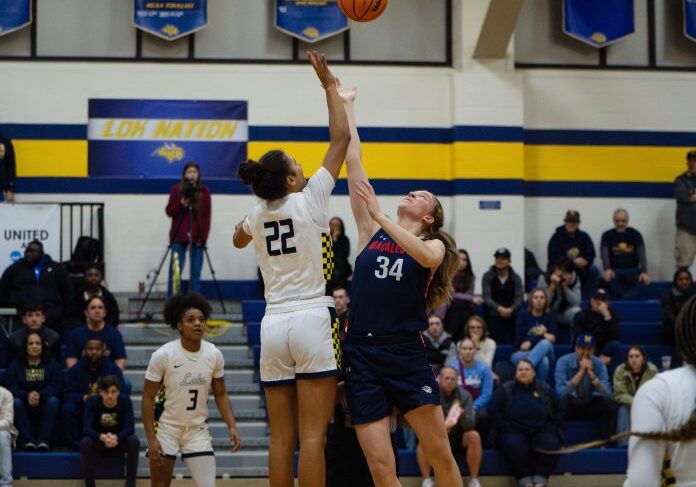 Players jump for basketball in game
