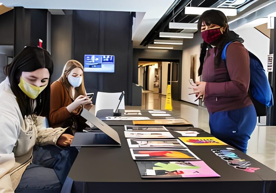Group examining art pieces with masks on