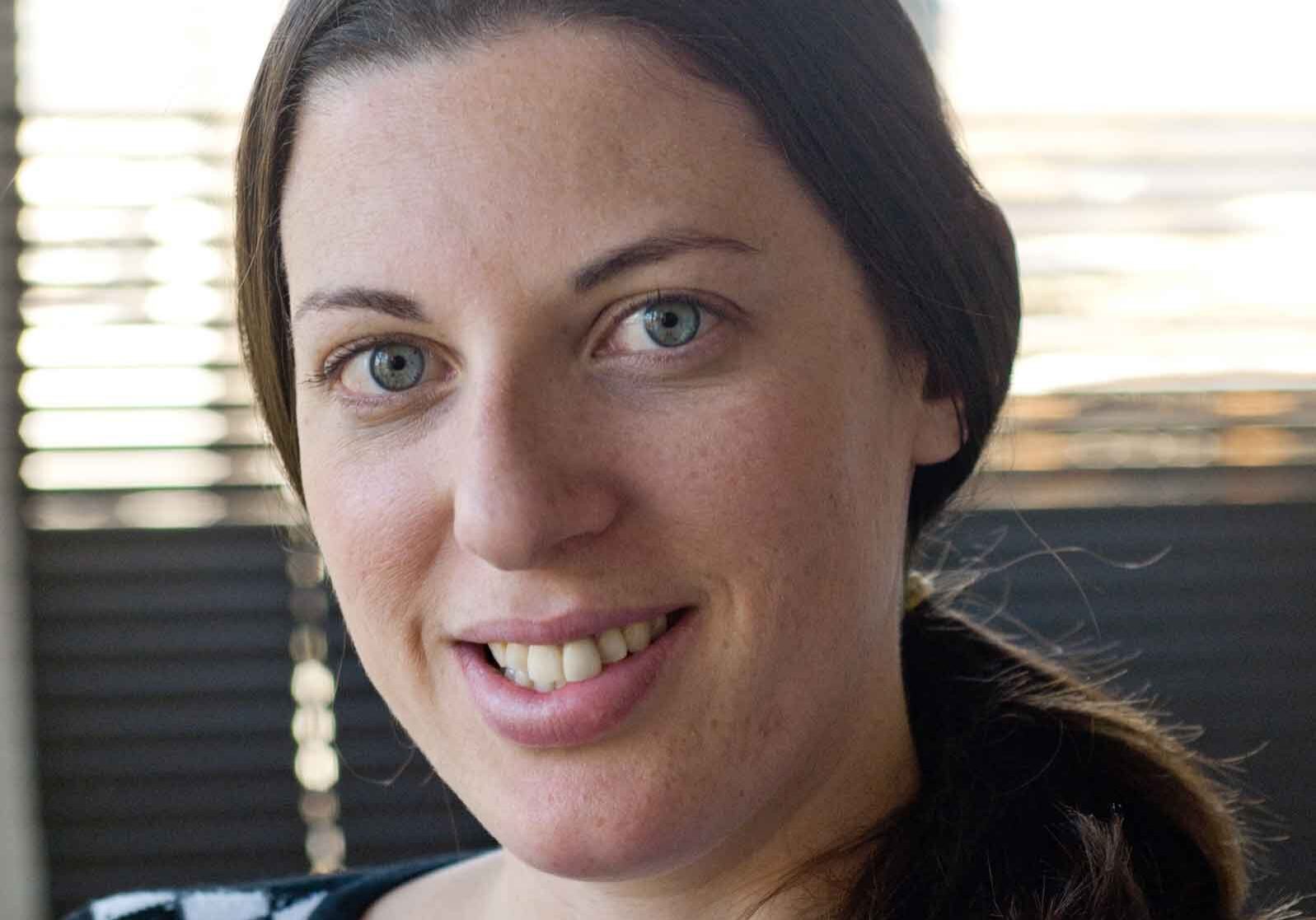 Woman with dark hair smiling at camera