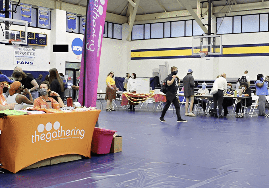 Indoor event with people and colorful booths.