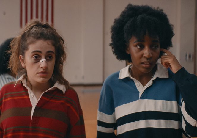 Two women in striped shirts indoors.