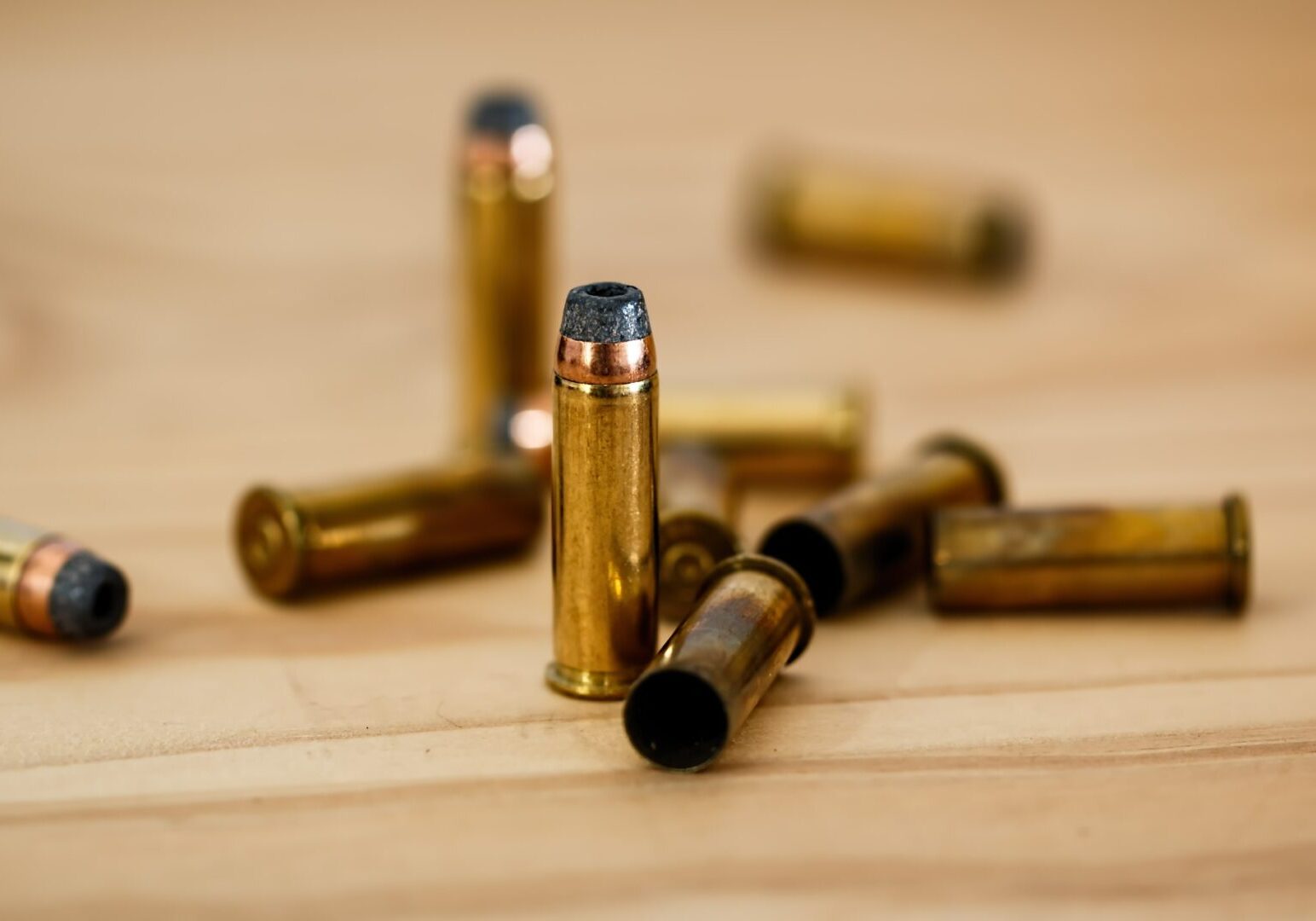 Brass bullets on wooden background