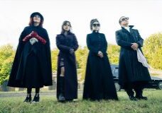 People in black cloaks standing outside