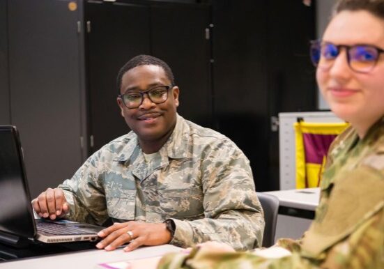 Military personnel working on laptops