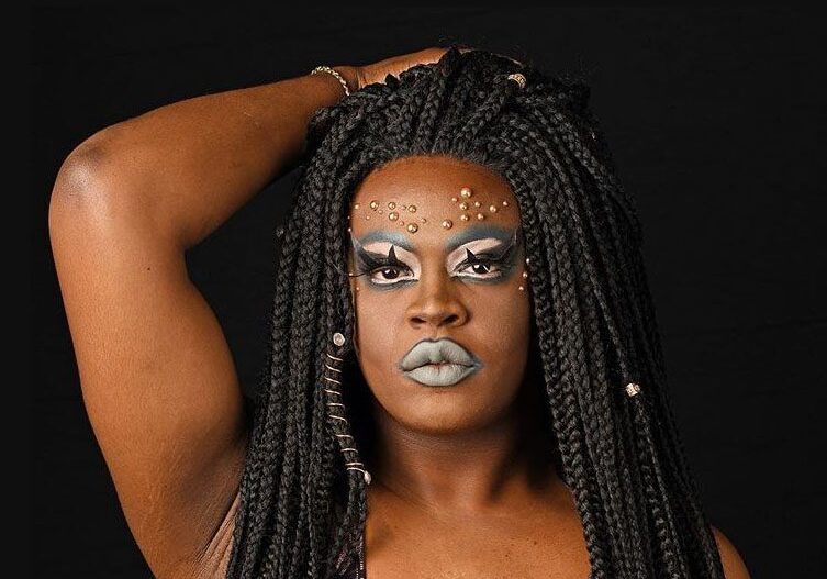 Person with braided hair and bold makeup