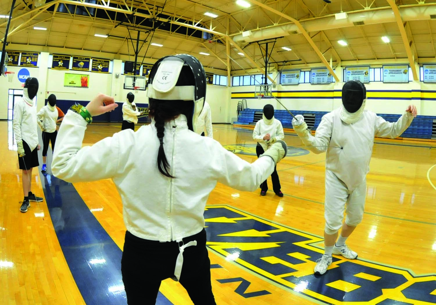 Fencing practice in gymnasium