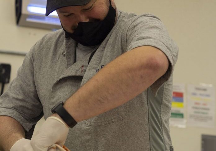 Man wearing mask and gloves cooking
