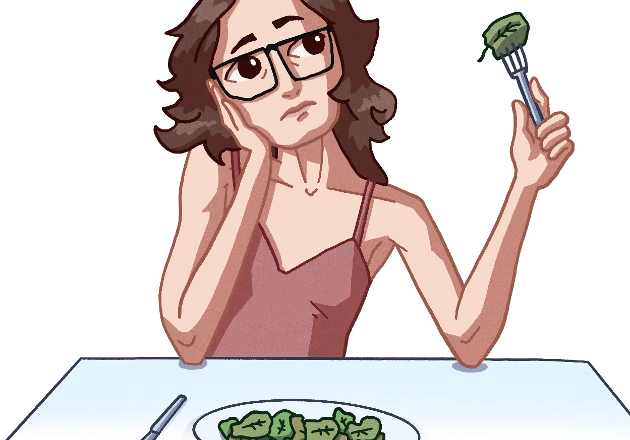 Contemplative woman with spinach on fork
