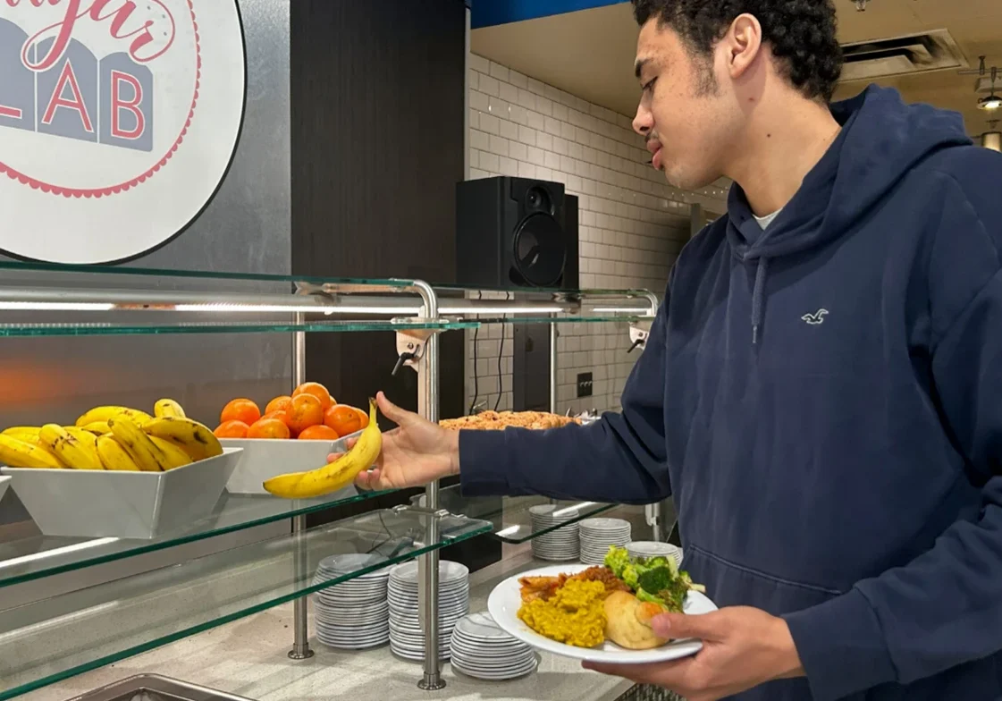 Individual holding plate at salad bar