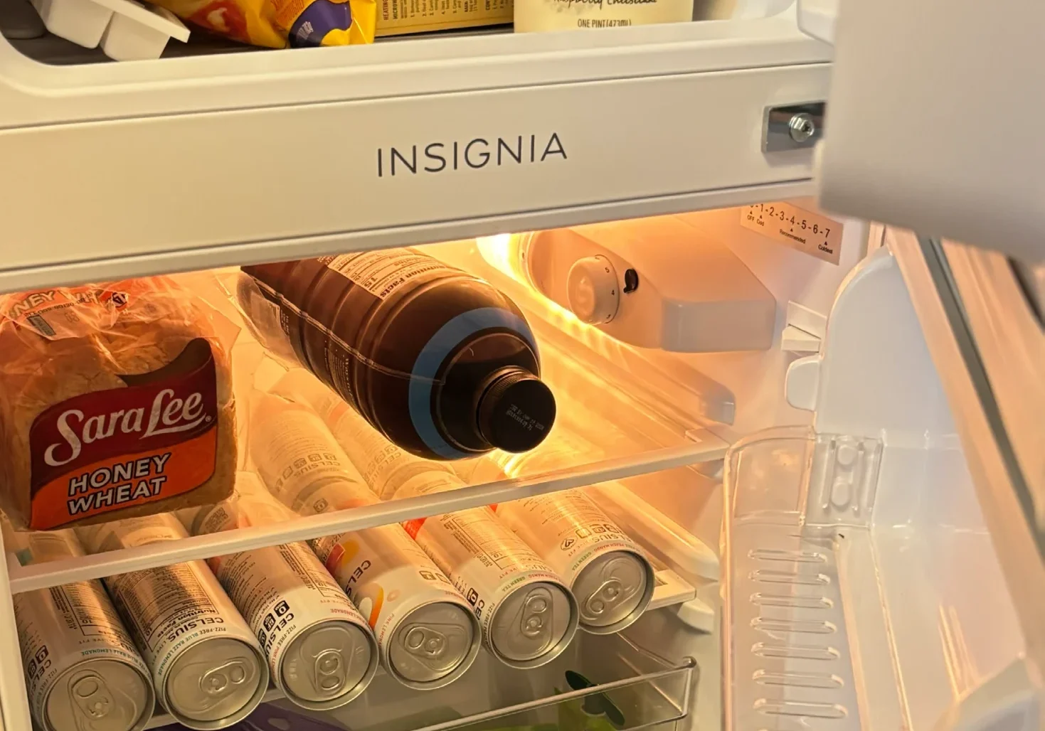 Open fridge with various food items inside
