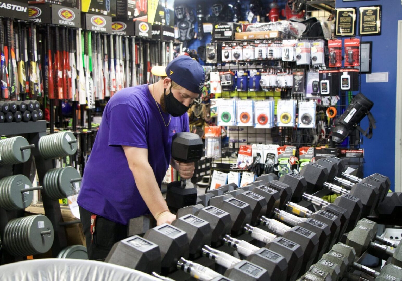 Man selecting dumbbell in sports store