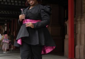 Woman in black and pink outfit smiling