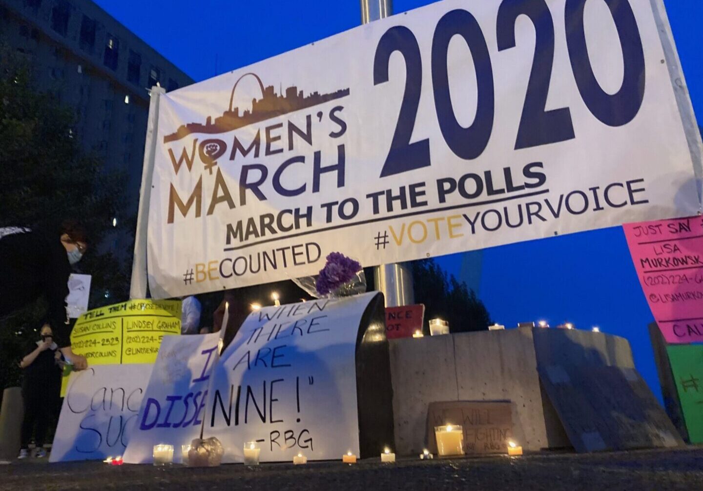 Protest signs and lit candles at rally