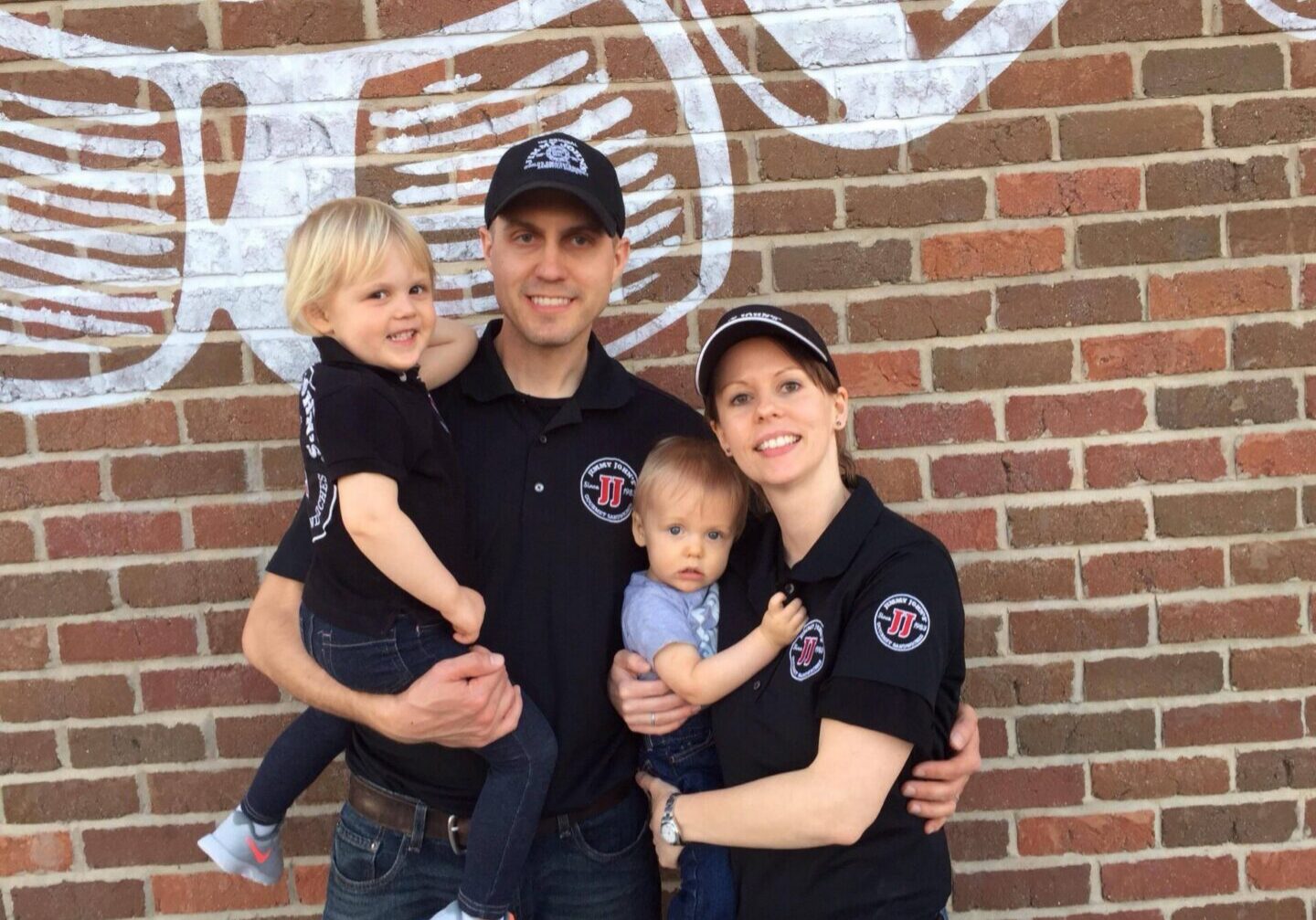 Family in matching outfits against brick wall