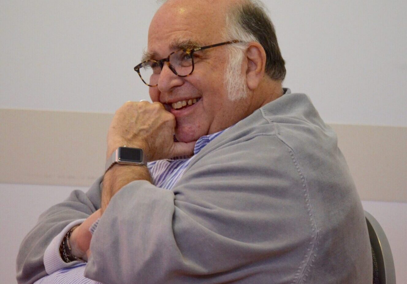 Elderly man laughing in a chair