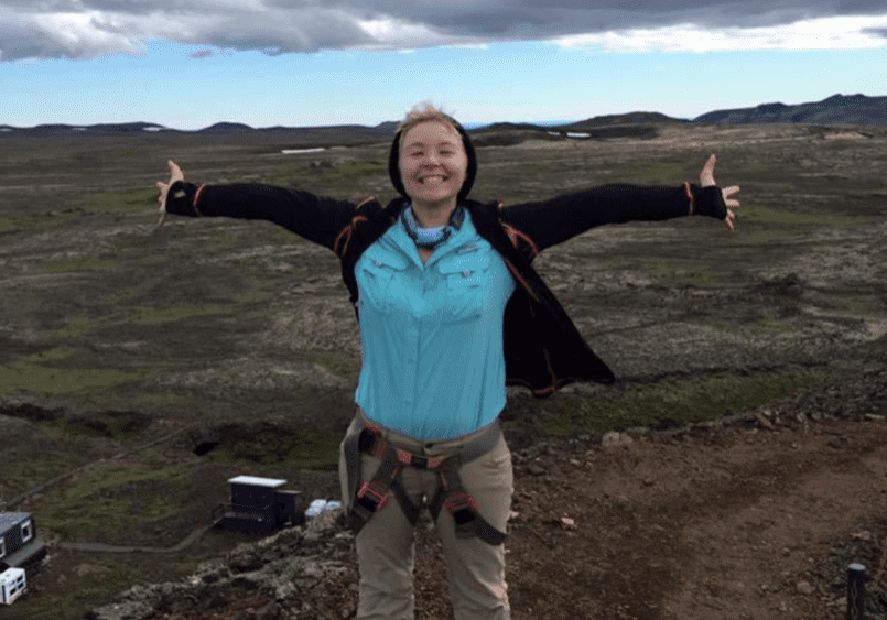 Person standing with open arms outdoors