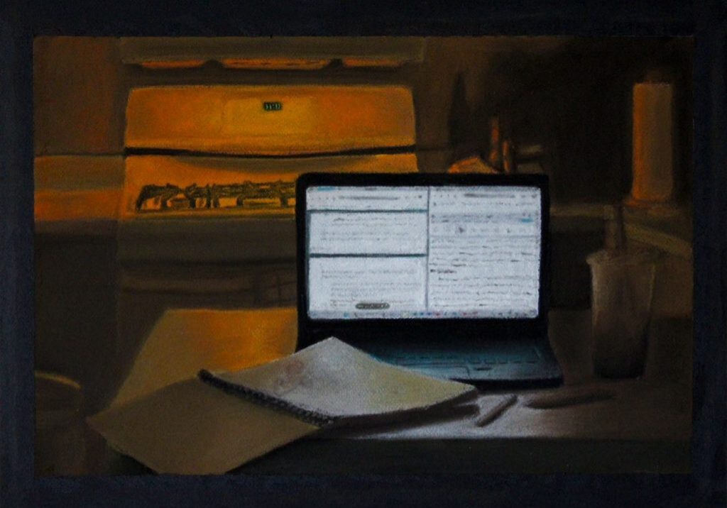 Notebook and drink beside a laptop