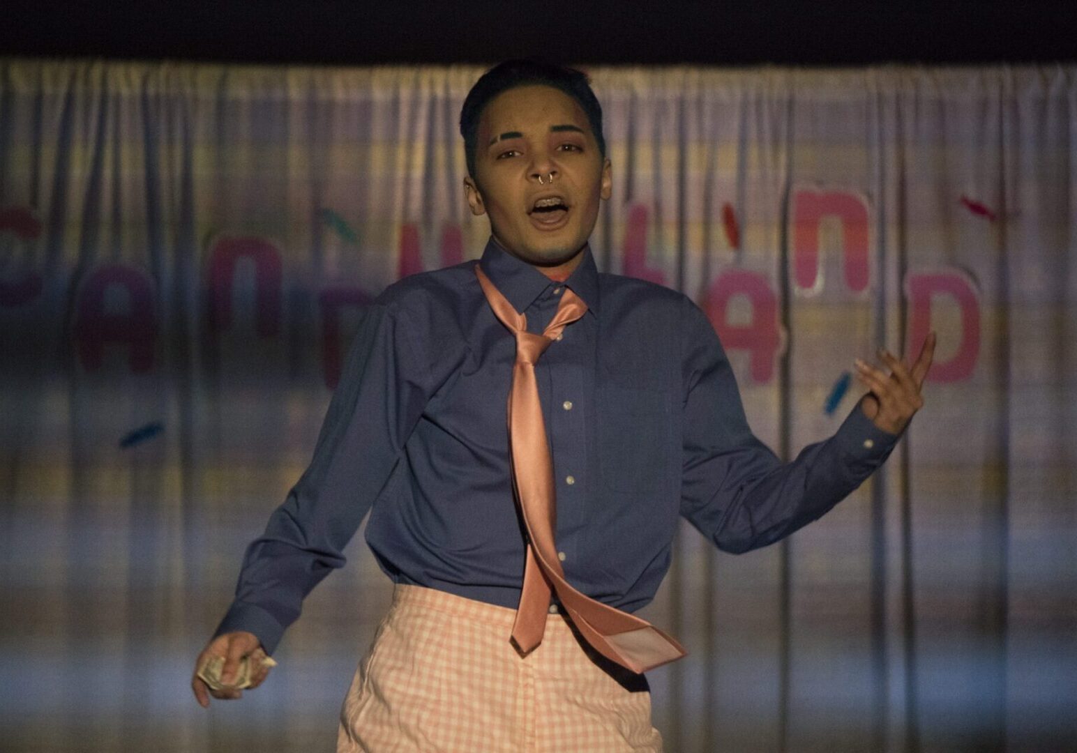 Person singing in blue shirt and tie