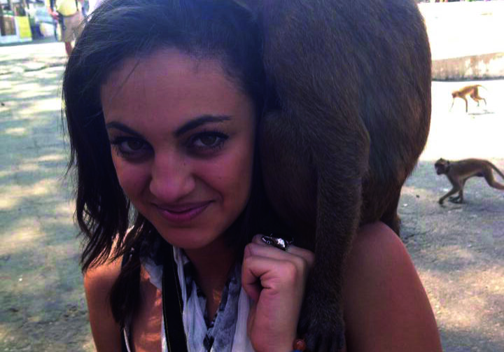 Smiling woman and monkey posing together
