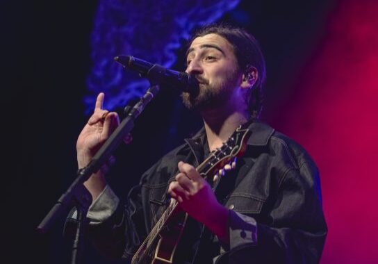Musician performing on stage with guitar