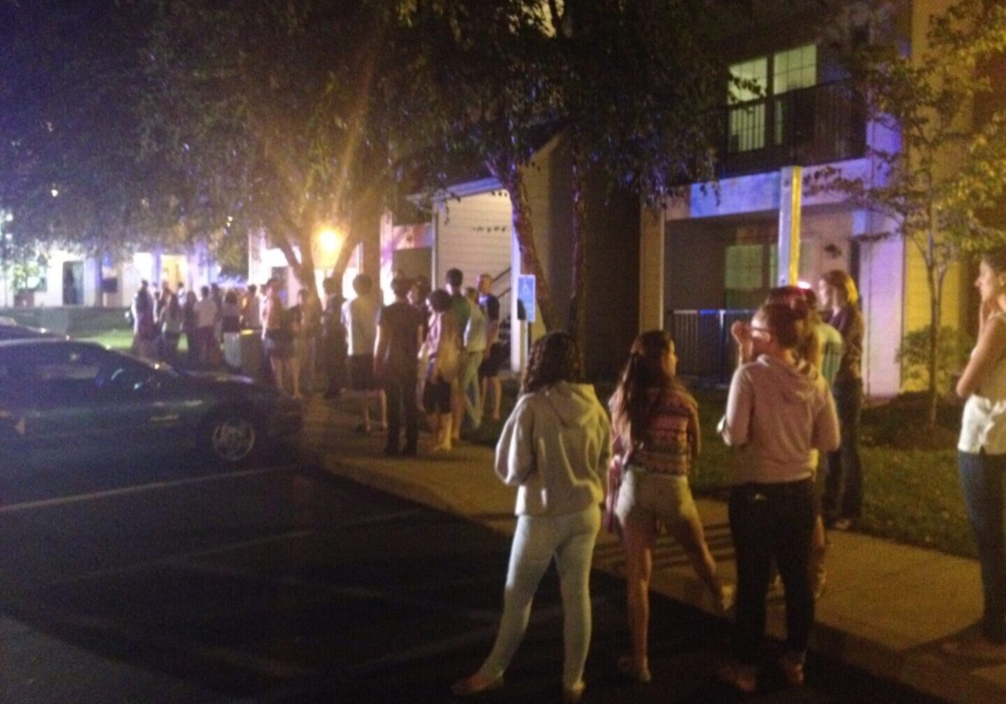 Residents standing outside illuminated building