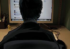 Person using computer in dim room