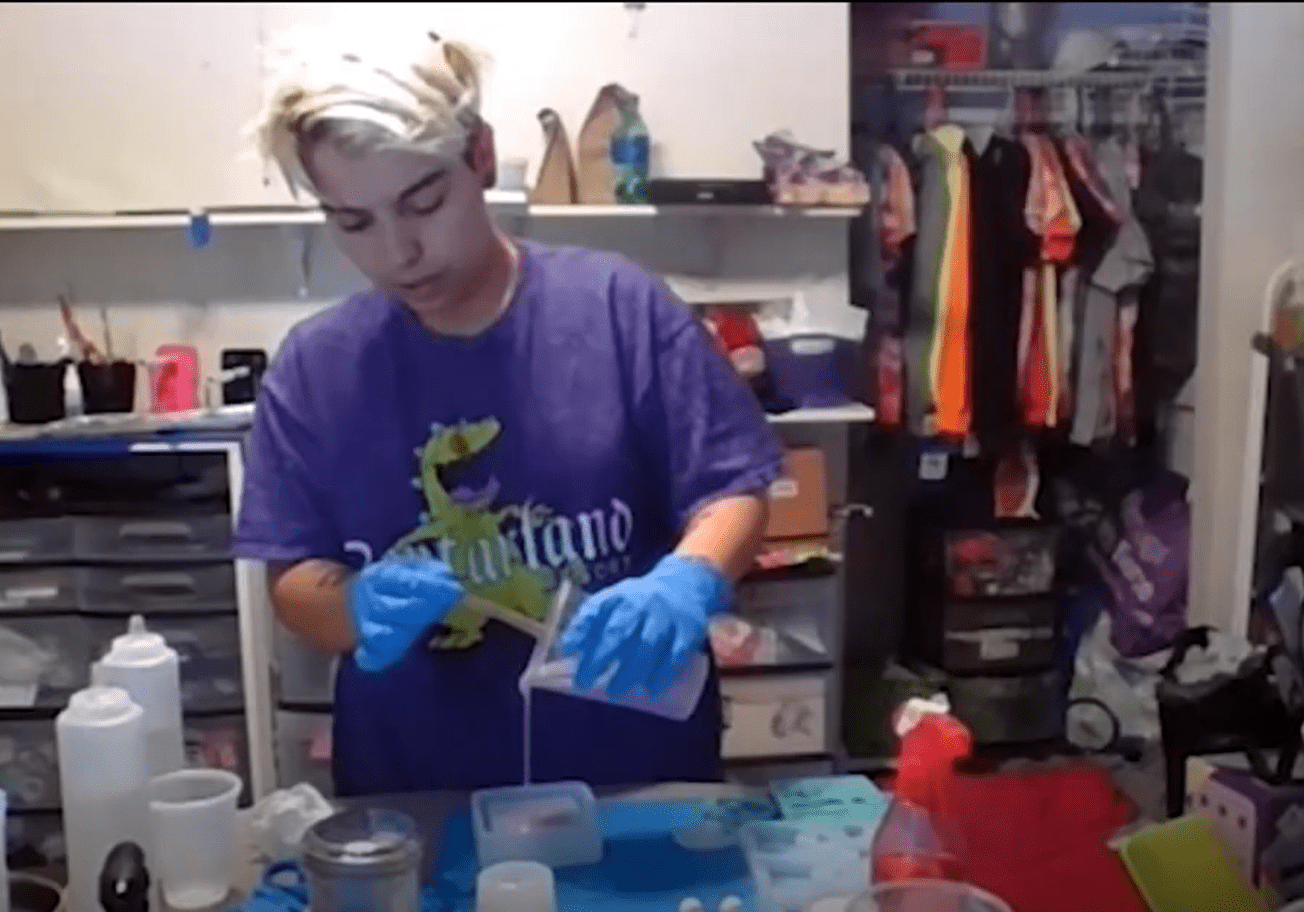 Individual wearing gloves working with containers.