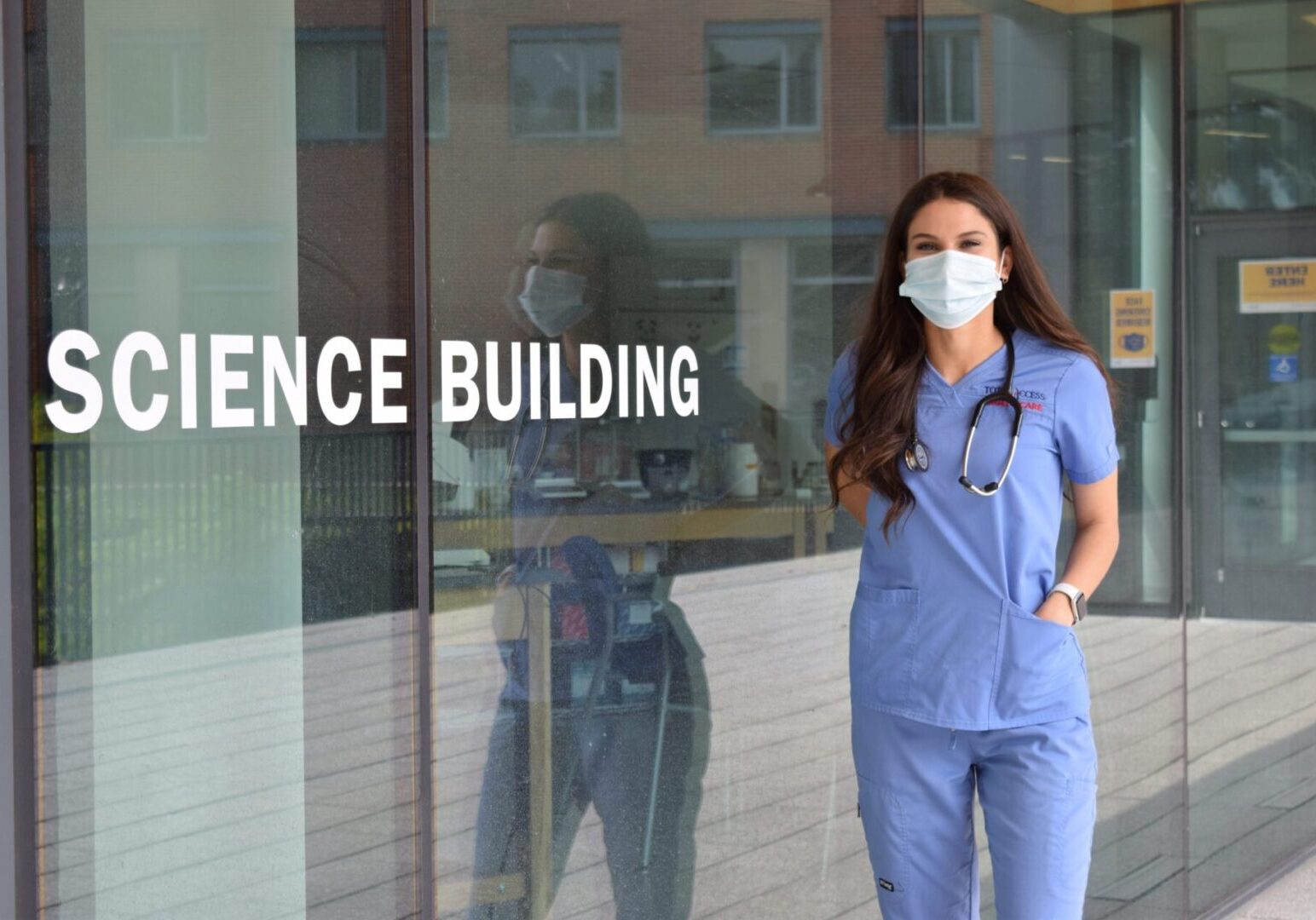 Healthcare worker wearing mask near building